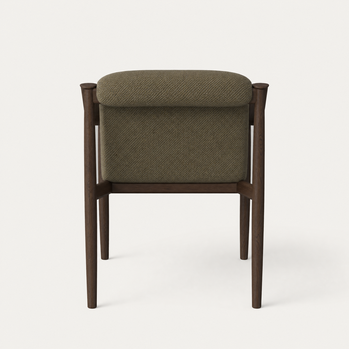 Rich Olive Green upholstery sits within the exposed sculptural frame of Ramón Esteve’s Tibeto Dining Chair, showcased by ACERKA Miami in Dark Oak.