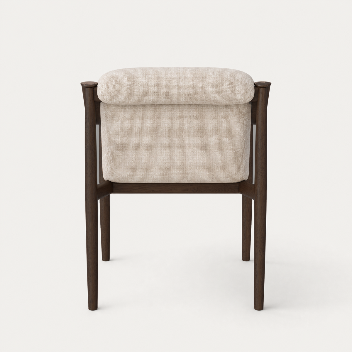 Sculptural timber arms sweep around the upholstered interior of the Tibeto Dining Chair by Ramón Esteve, showcased at ACERKA Miami in Dark Oak and Stone Beige.