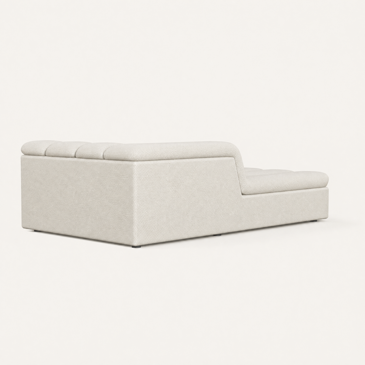 The Devi Chaise Module features textured Alpine White upholstery, a generous lounging surface, and a softly rounded backrest.