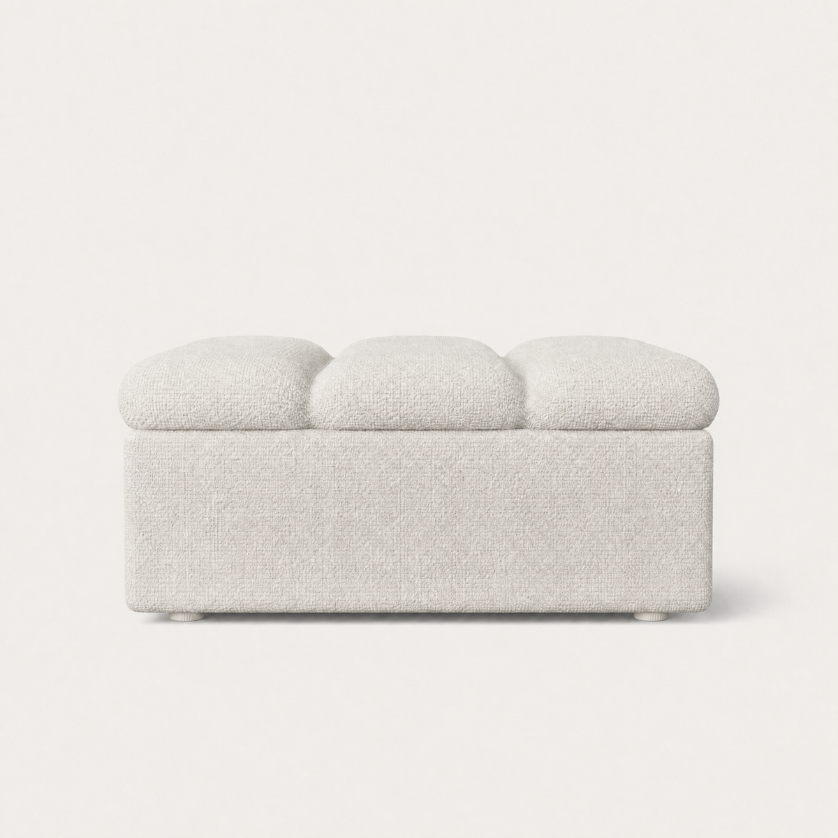 A modern ottoman upholstered in a textured fabric in a white color, shown from a straight-on front angle against a clean, solid off-white background.