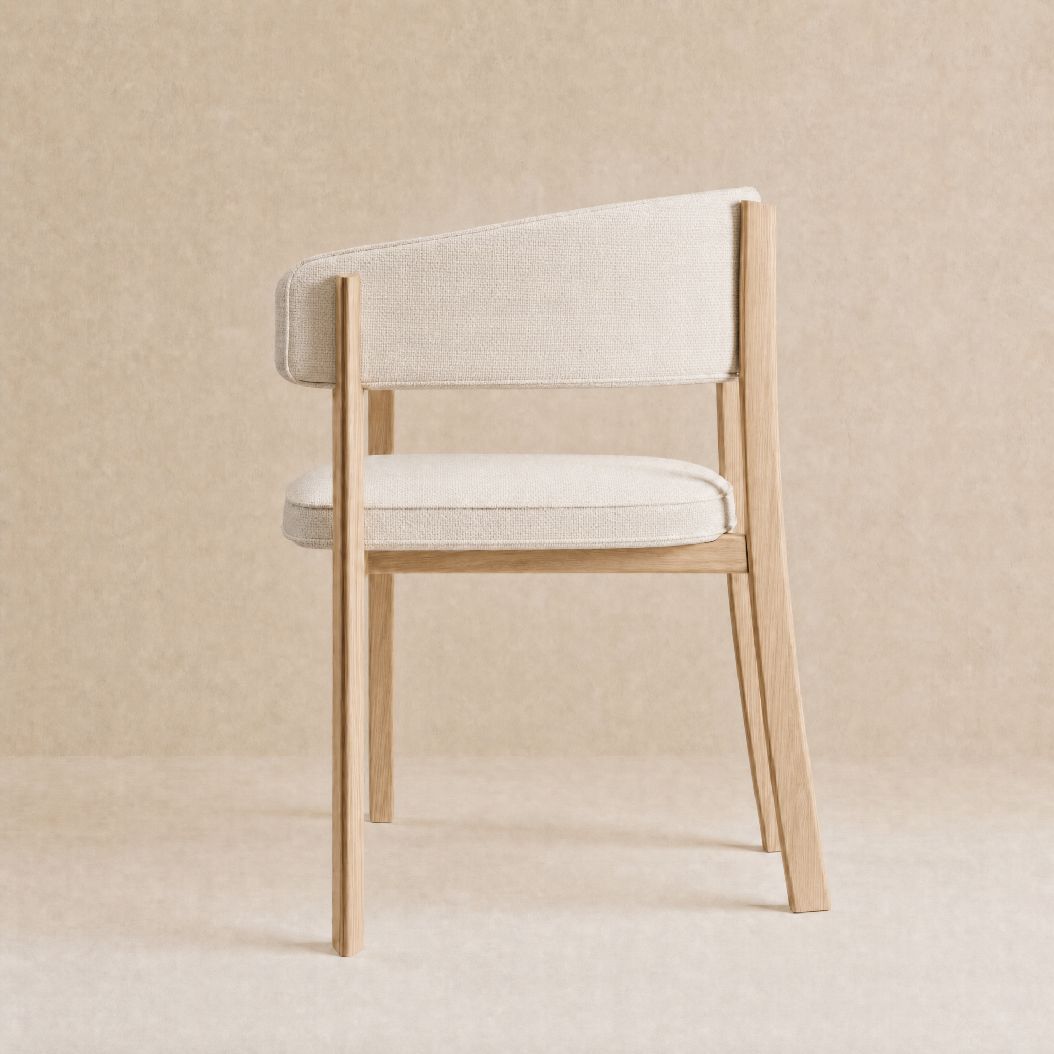 A modern accent chair with a light beige textured fabric seat and backrest, supported by a natural light wood frame, set against a matching beige textured background.