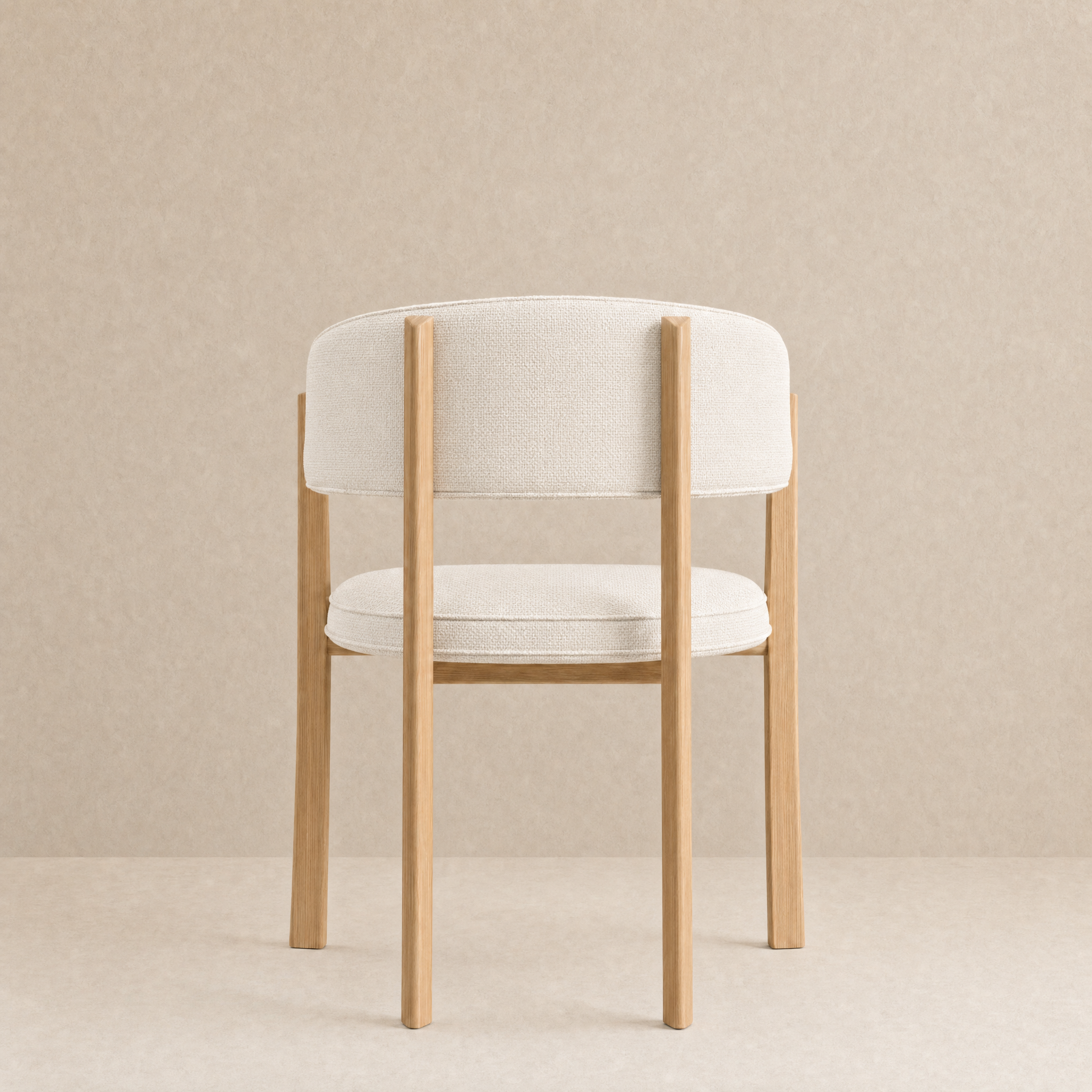 A modern dining chair with a light beige upholstered seat and curved backrest, supported by a natural light wood frame, set against a neutral beige textured background.